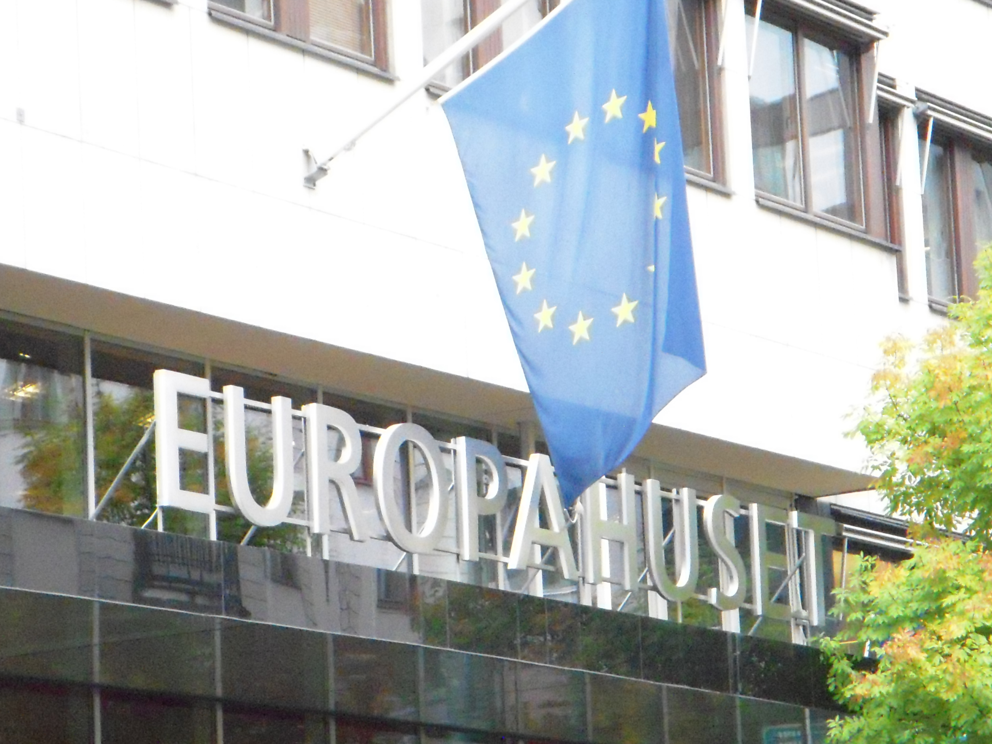 Europahuset fasad, med EU-flaggan och skylt med Europahuset i stora boksta ovanför entrén.