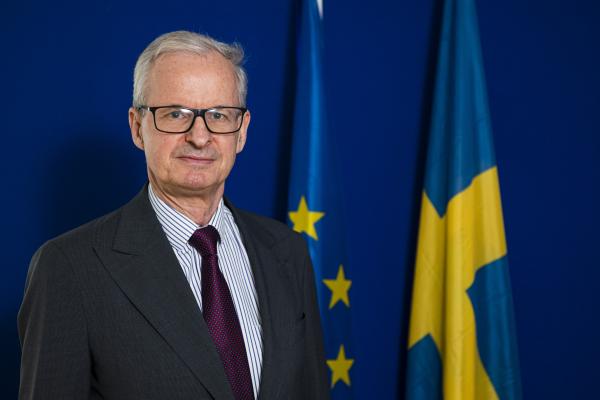 Christian Danielsson framför en svensk flagga och en EU-flagga